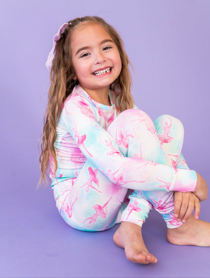 Young girl wearing a colorful ballet-themed outfit on a purple background