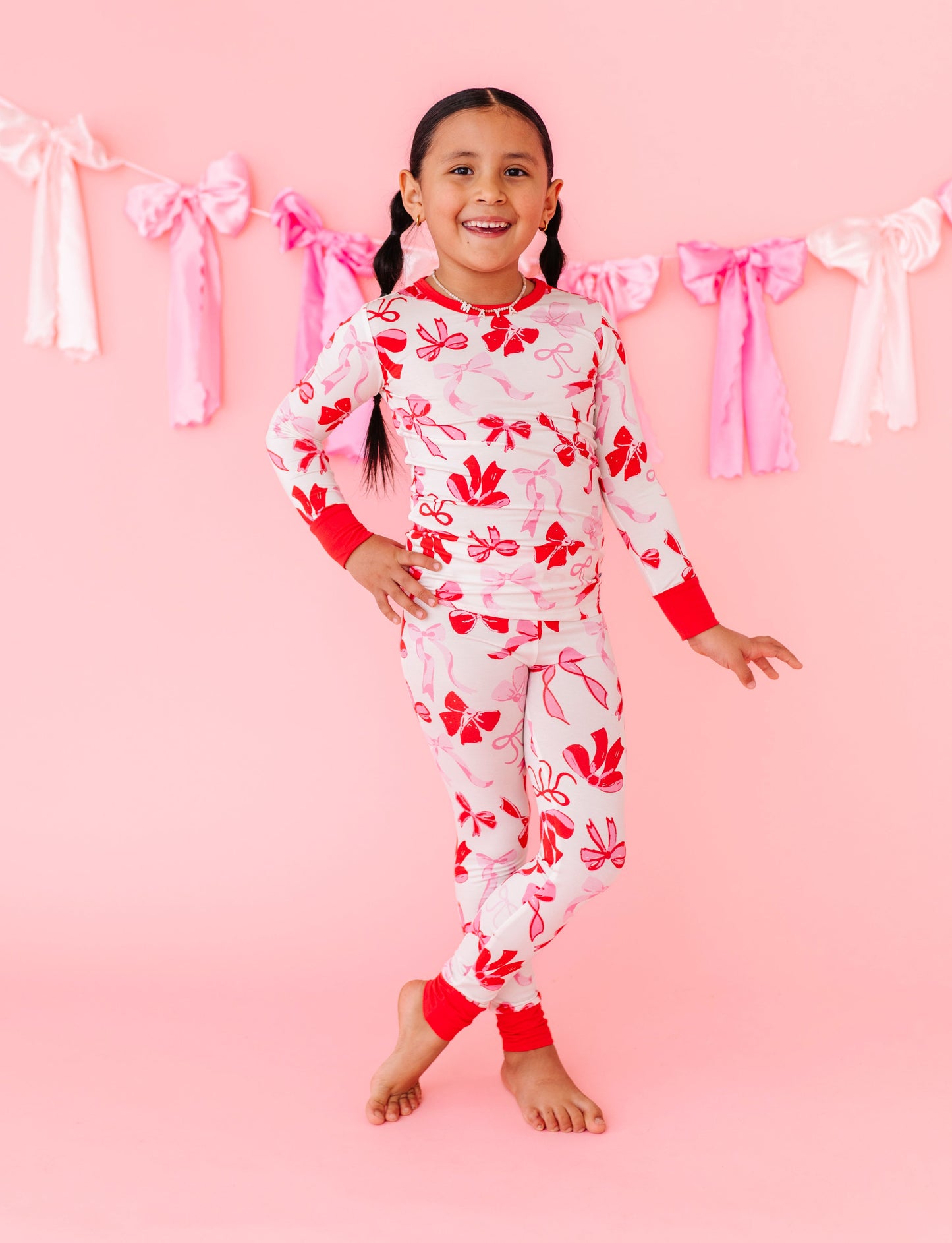 Child posing in Blushing Bows bamboo pajamas highlighting snug, stretchy fit