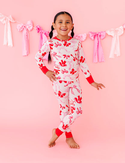 Child posing in Blushing Bows bamboo pajamas highlighting snug, stretchy fit