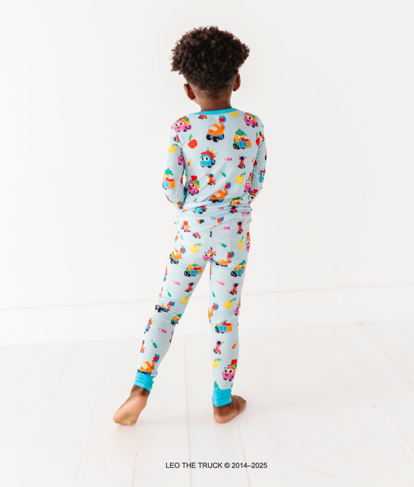 Little boy wearing a Leo the Truck bamboo 2-piece set on a white background