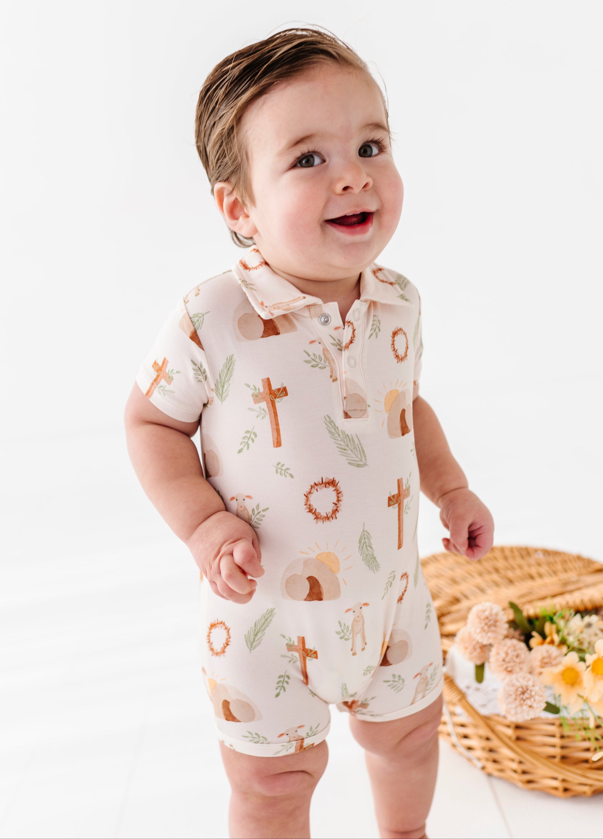 Baby wearing a romper with religious symbols on a white background