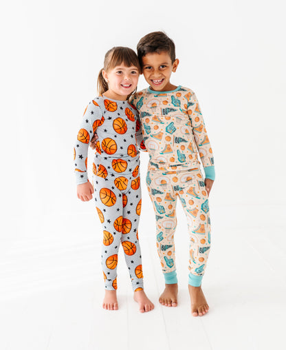 Two children wearing basketball themed pajamas on a white background