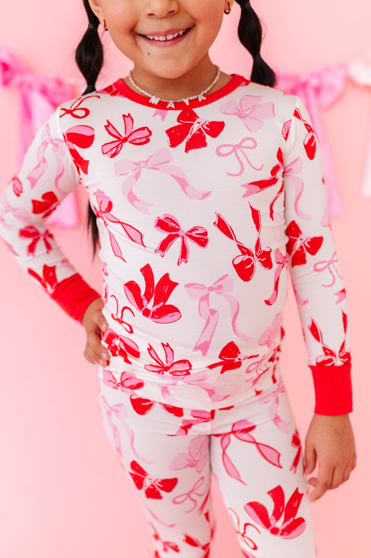 Close-up of Blushing Bows bamboo pajama fabric showing soft bow pattern