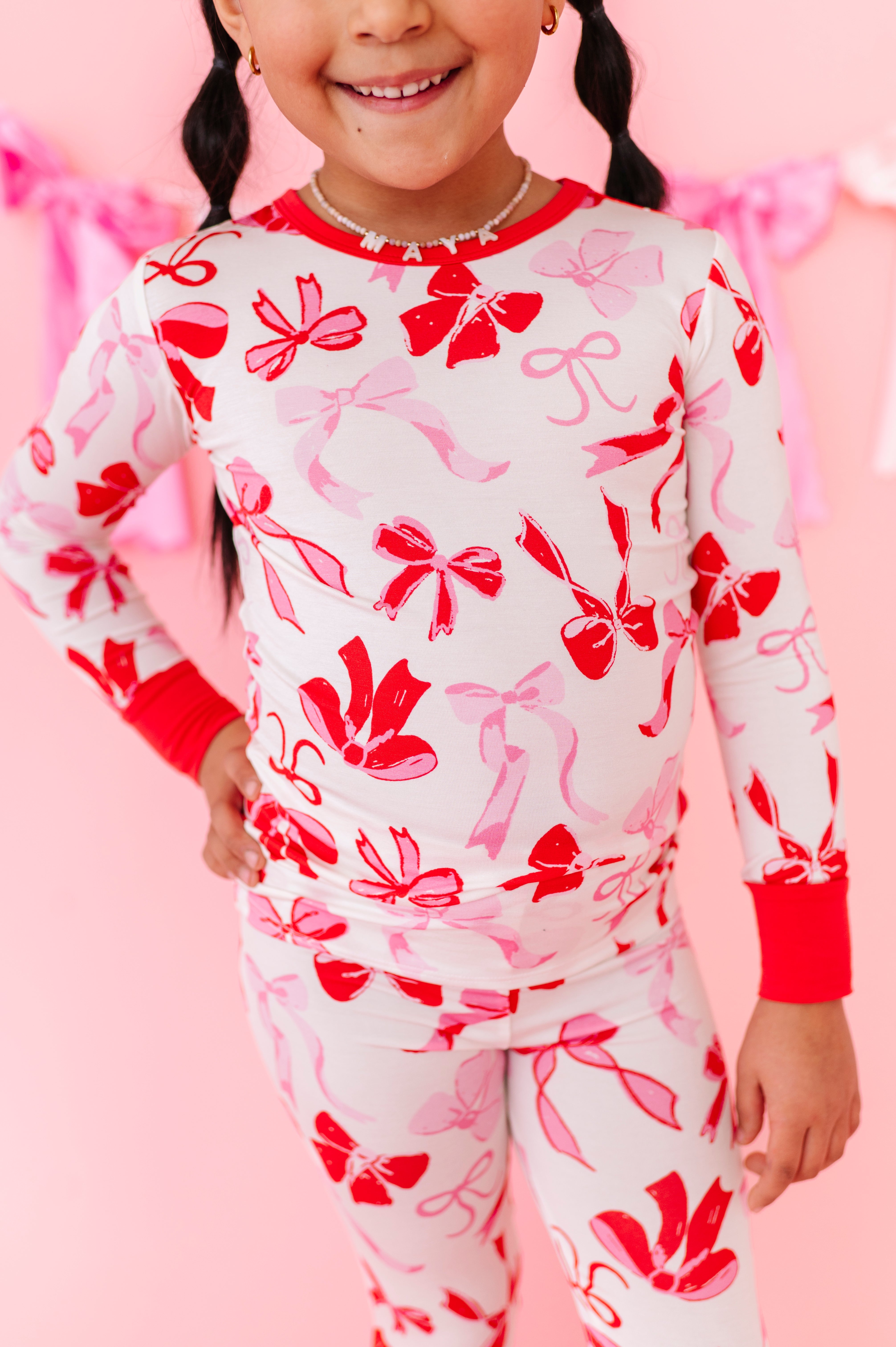 Close-up of Blushing Bows bamboo pajama fabric showing soft bow pattern
