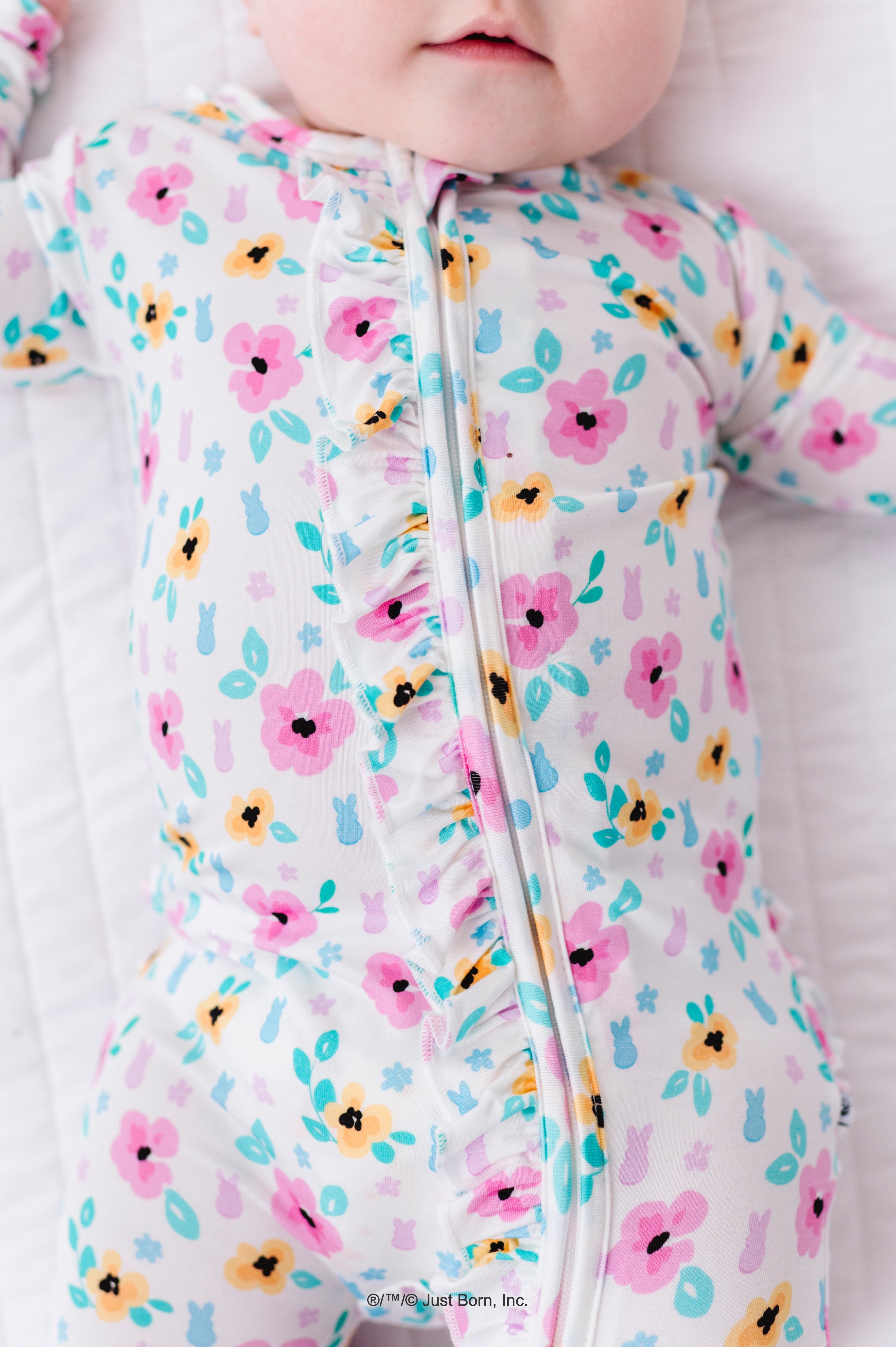 Baby wearing a floral PEEPS® romper on a white background