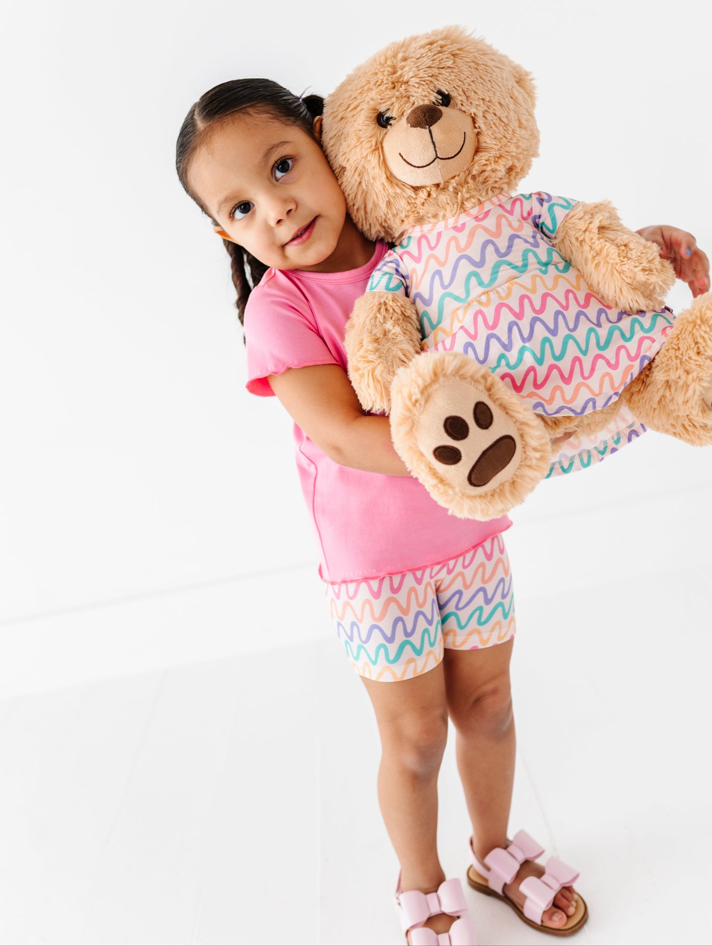 Little girl and teddy bear wearing matching bamboo outfits