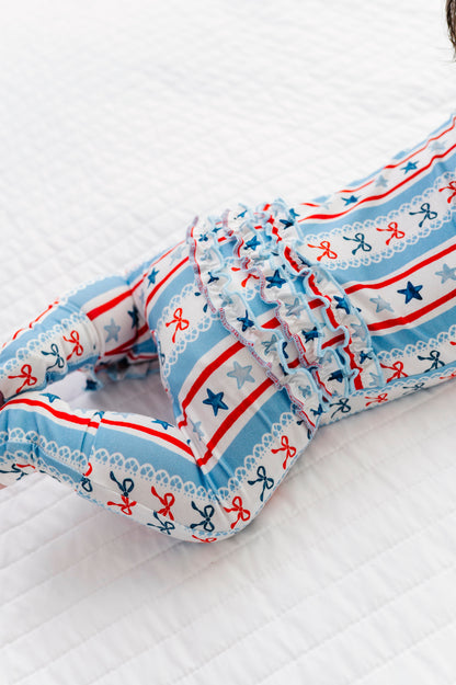 Baby wearing a bamboo convertible romper with red, white, and blue pattern on a white background