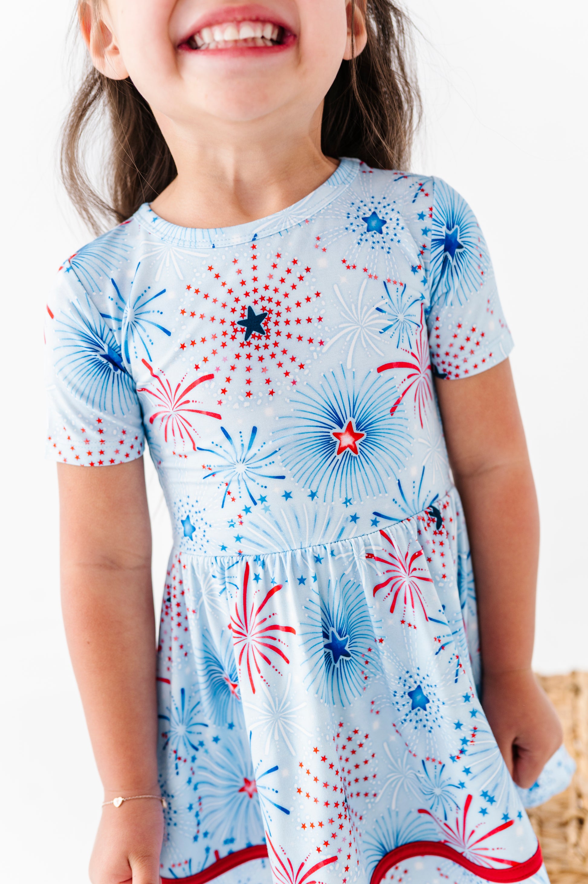 Child wearing a bamboo dress with fireworks pattern on a white background