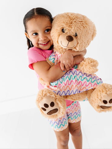 Child and teddy bear wearing matching bamboo peplum tops 