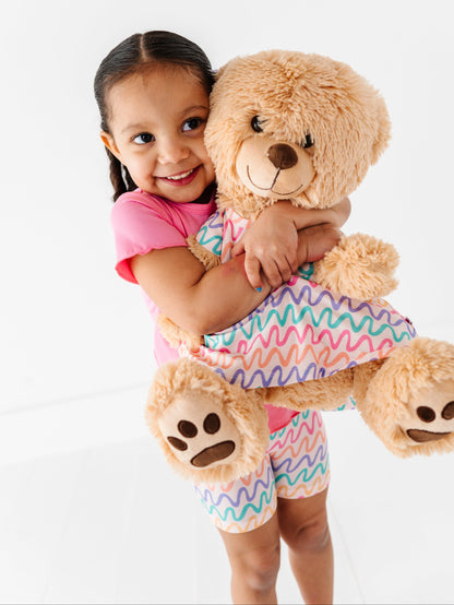Child and teddy bear wearing matching bamboo peplum tops 