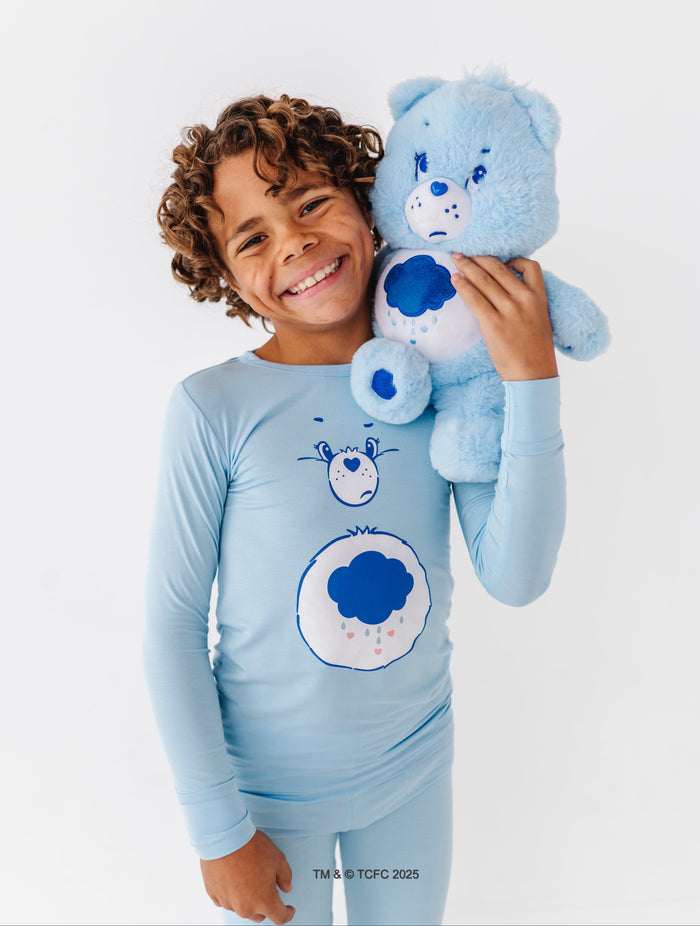 Child wearing Care Bears Grumpy Bear bamboo pajamas with blue cloud belly badge