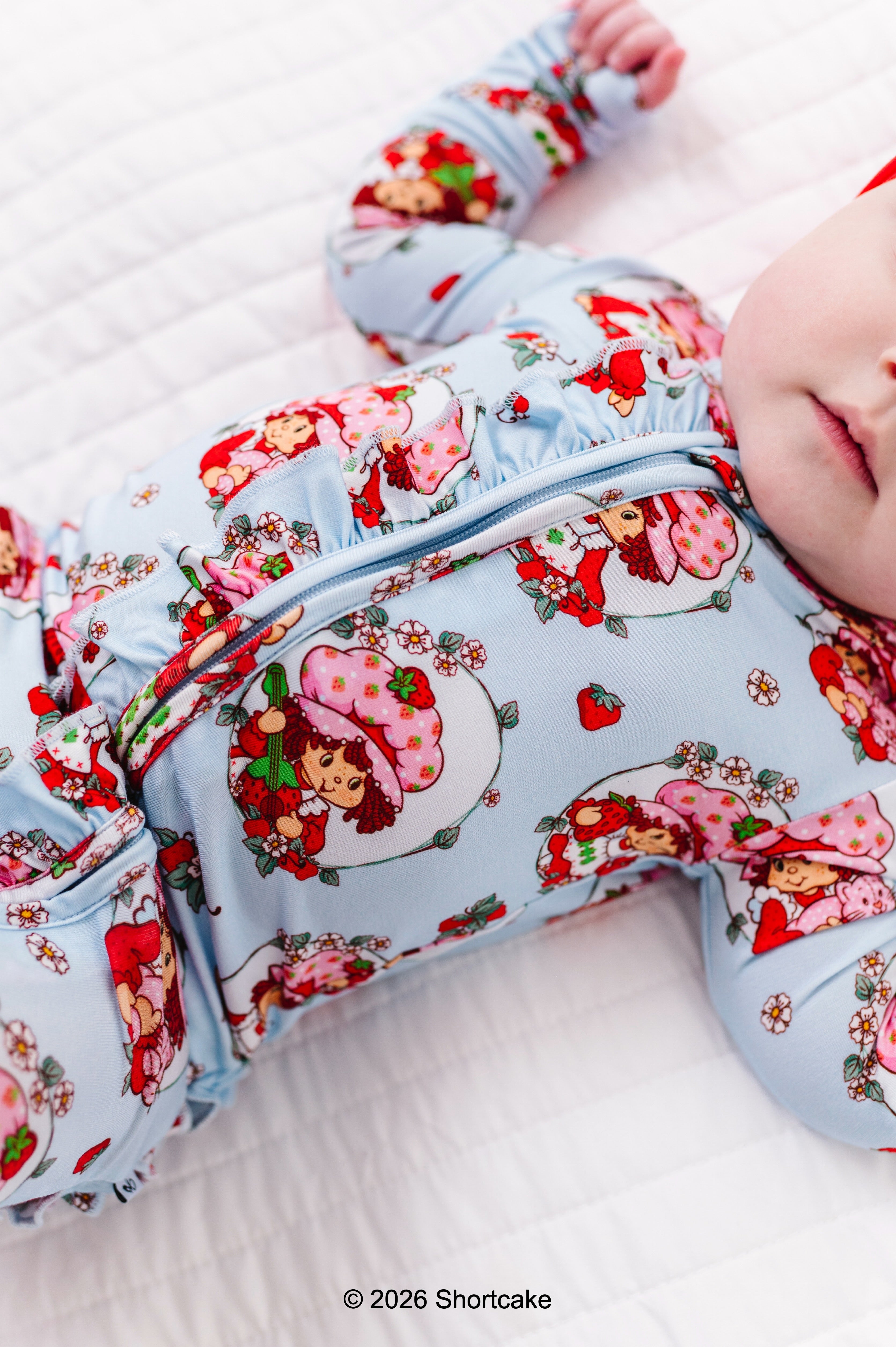 Baby wearing a Strawberry Shortcake™ bamboo convertible romper 