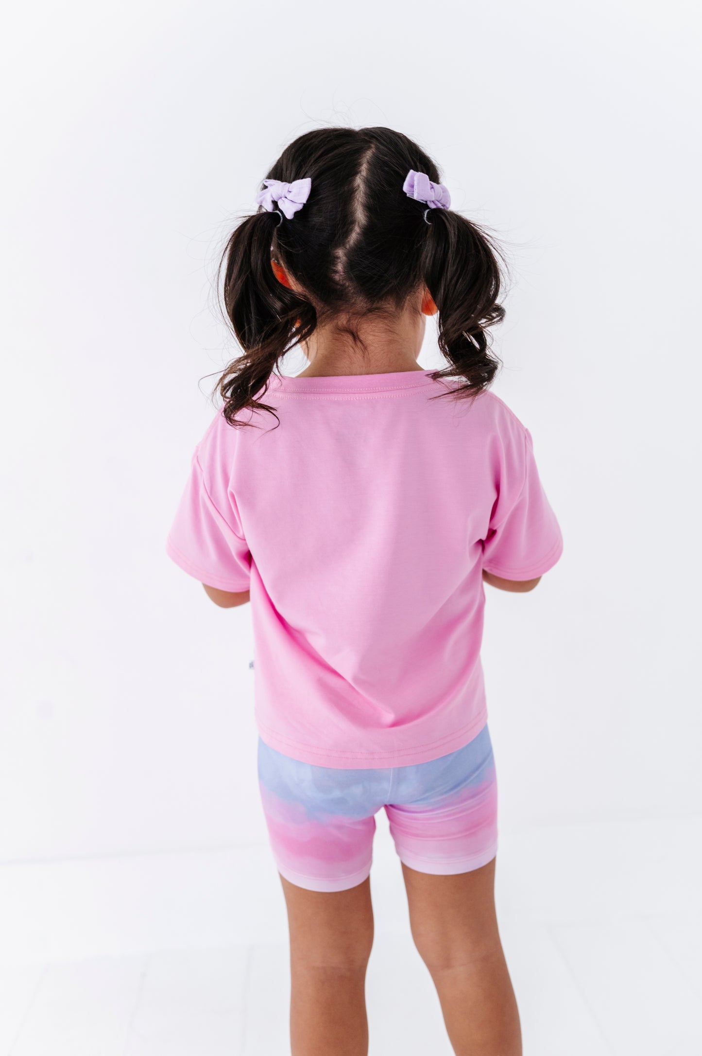 Child wearing a pink outfit with a white background
