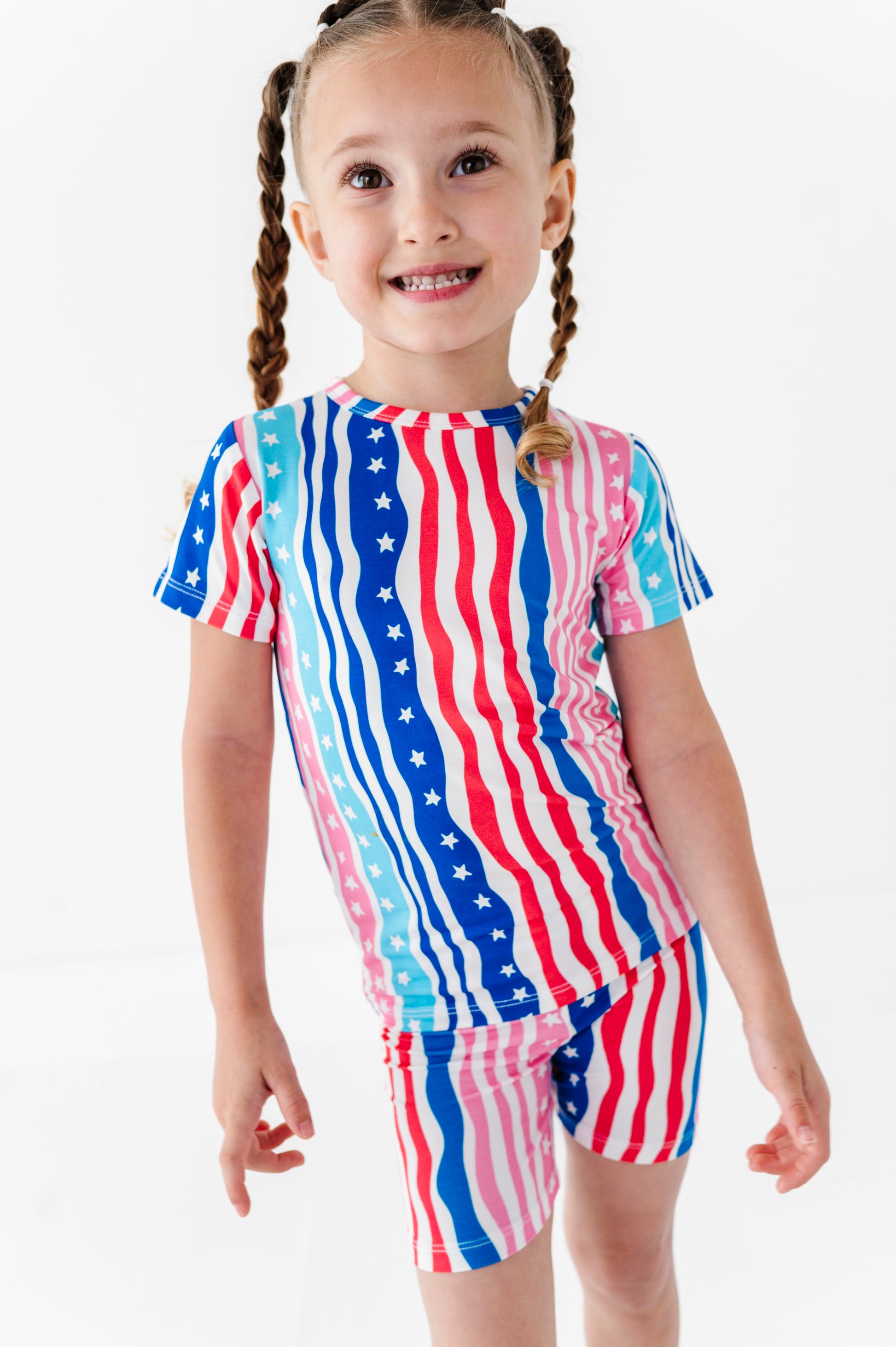 Child wearing a colorful American flag-themed bamboo pajama outfit on a white background