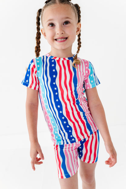 Child wearing a colorful American flag-themed bamboo pajama outfit on a white background