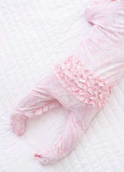 Pink camo baby outfit with ruffles on a white background