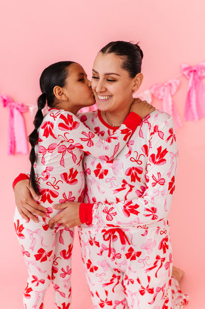 Child wearing Blushing Bows bamboo 2-piece pajamas with red and pink bow print