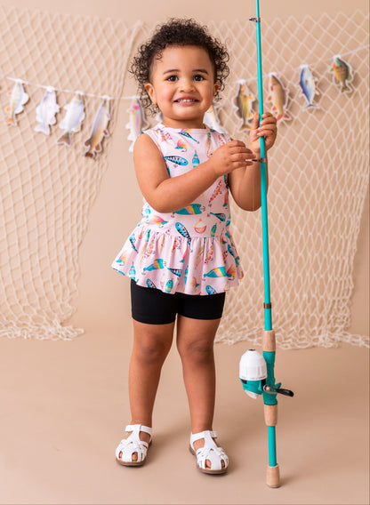 Child holding a fishing rod with a decorative net and fish banner in the background