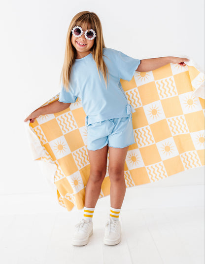 Girl holding a yellow and white checkered blanket on a white background