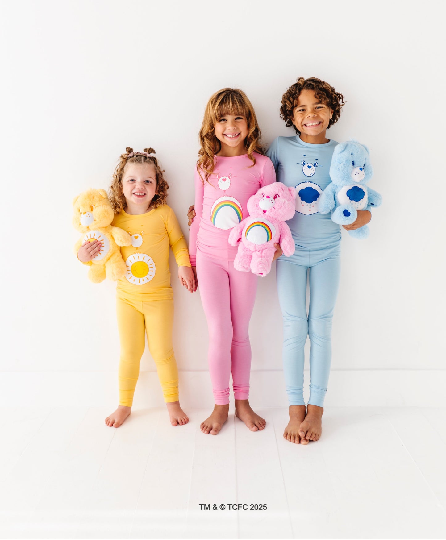 Kids matching Care Bears pajamas featuring Cheer Bear and rainbow design