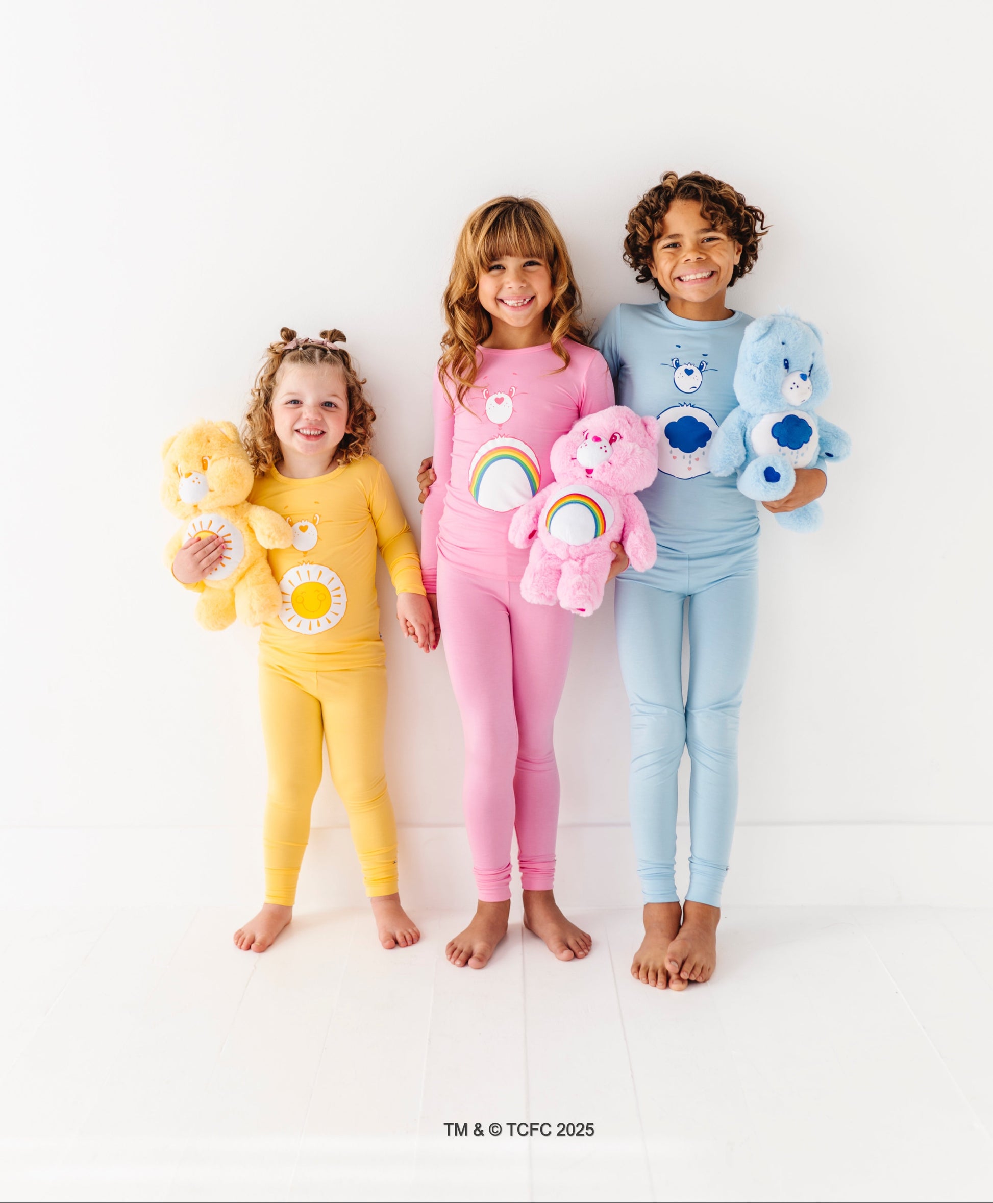 Kids matching Care Bears pajamas featuring Cheer Bear and rainbow design
