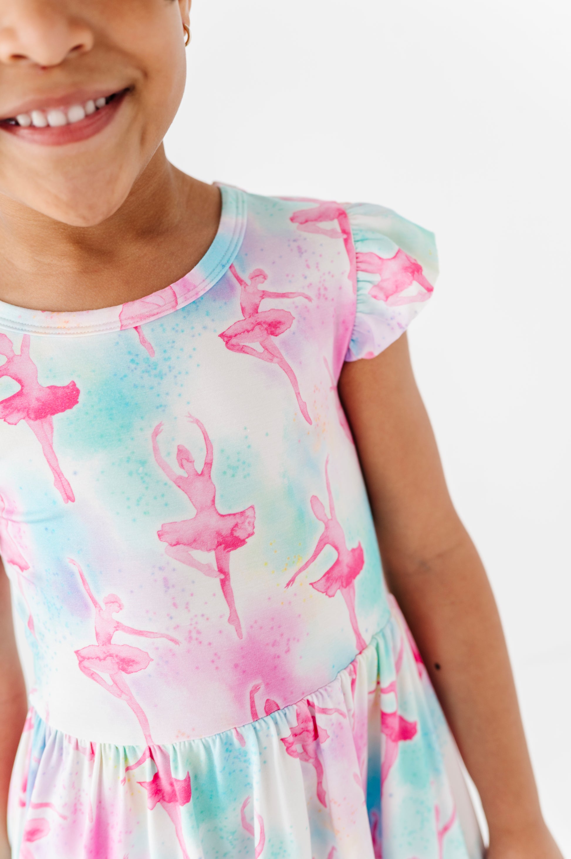Young girl wearing a bamboo dress with ballet dancer print on a white background
