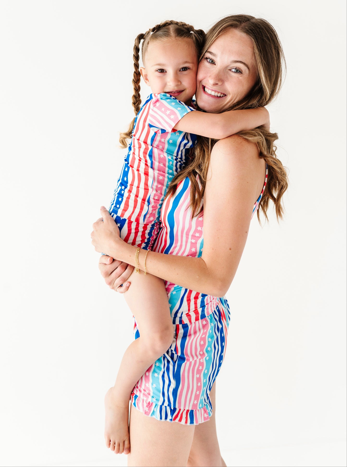 Mama and daughter wearing matching colorful bamboo short sets against a white background