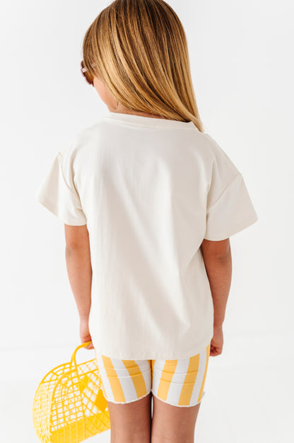Girl wearing a white t-shirt and yellow striped shorts holding a yellow basket on a white background