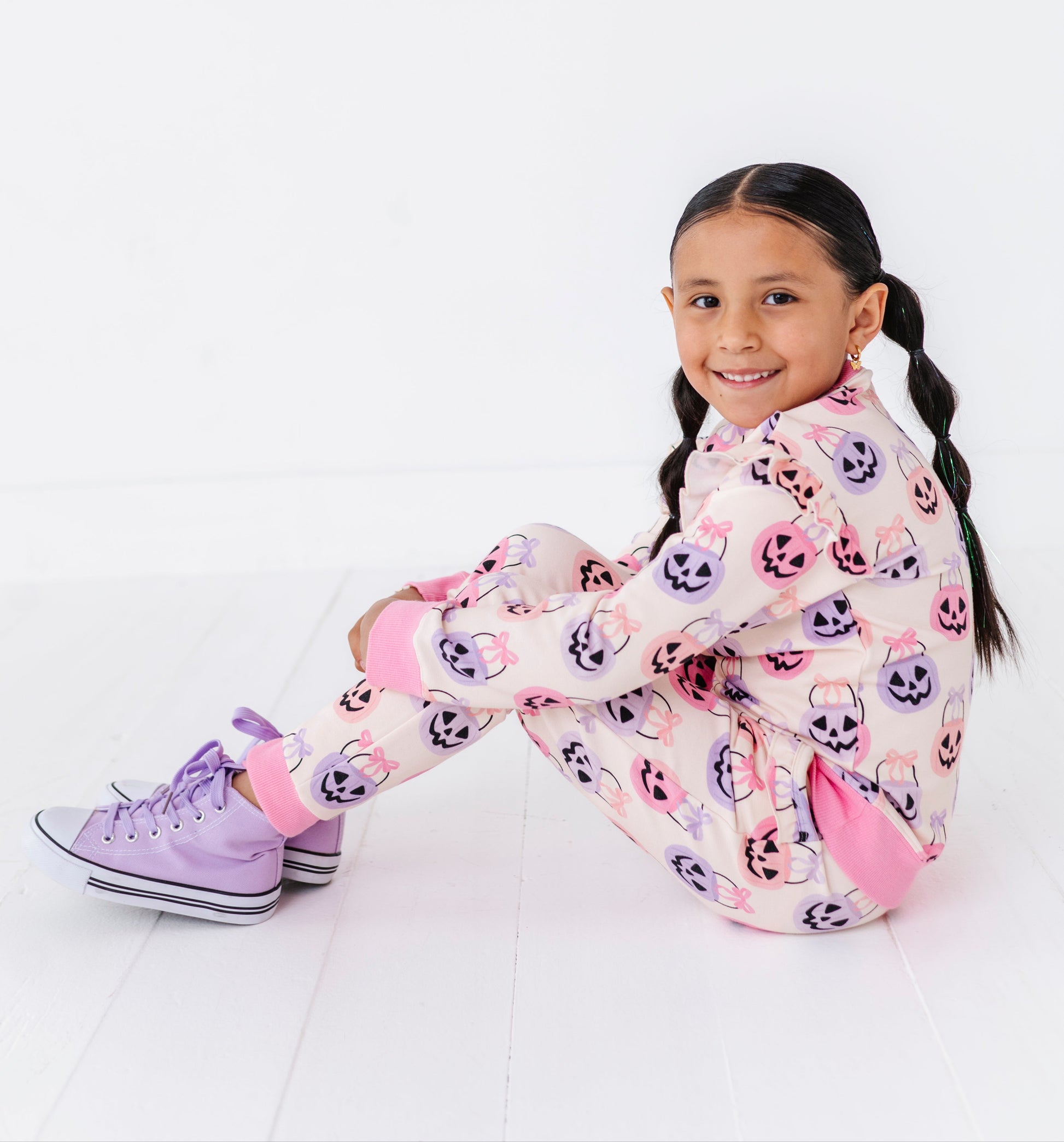 Young girl wearing a colorful Halloween bamboo jogger set with a white background