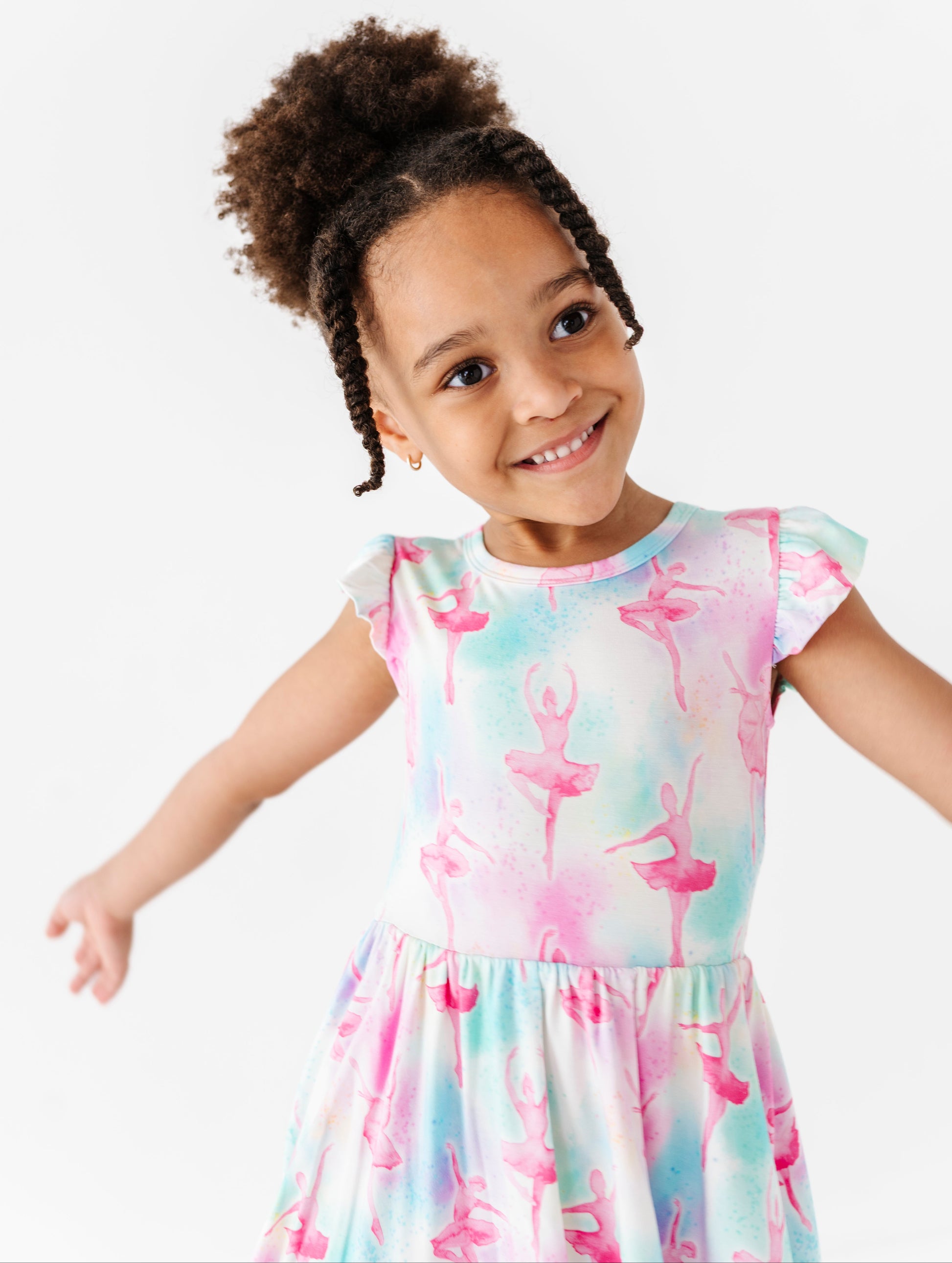 Child wearing a colorful bamboo dress with ballet dancer design on a white background