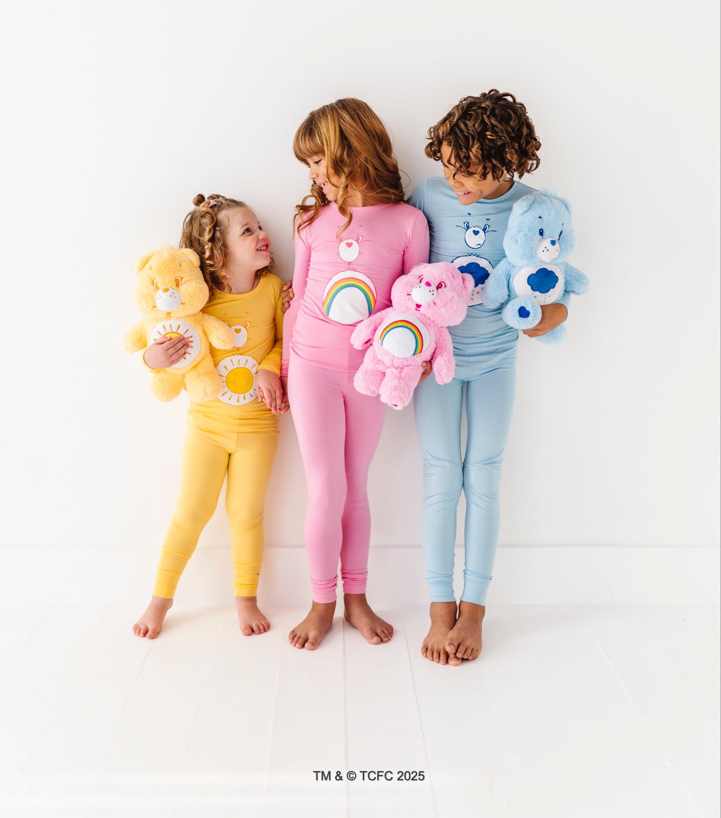 Child smiling in Grumpy Bear bamboo pajamas with official Care Bears artwork