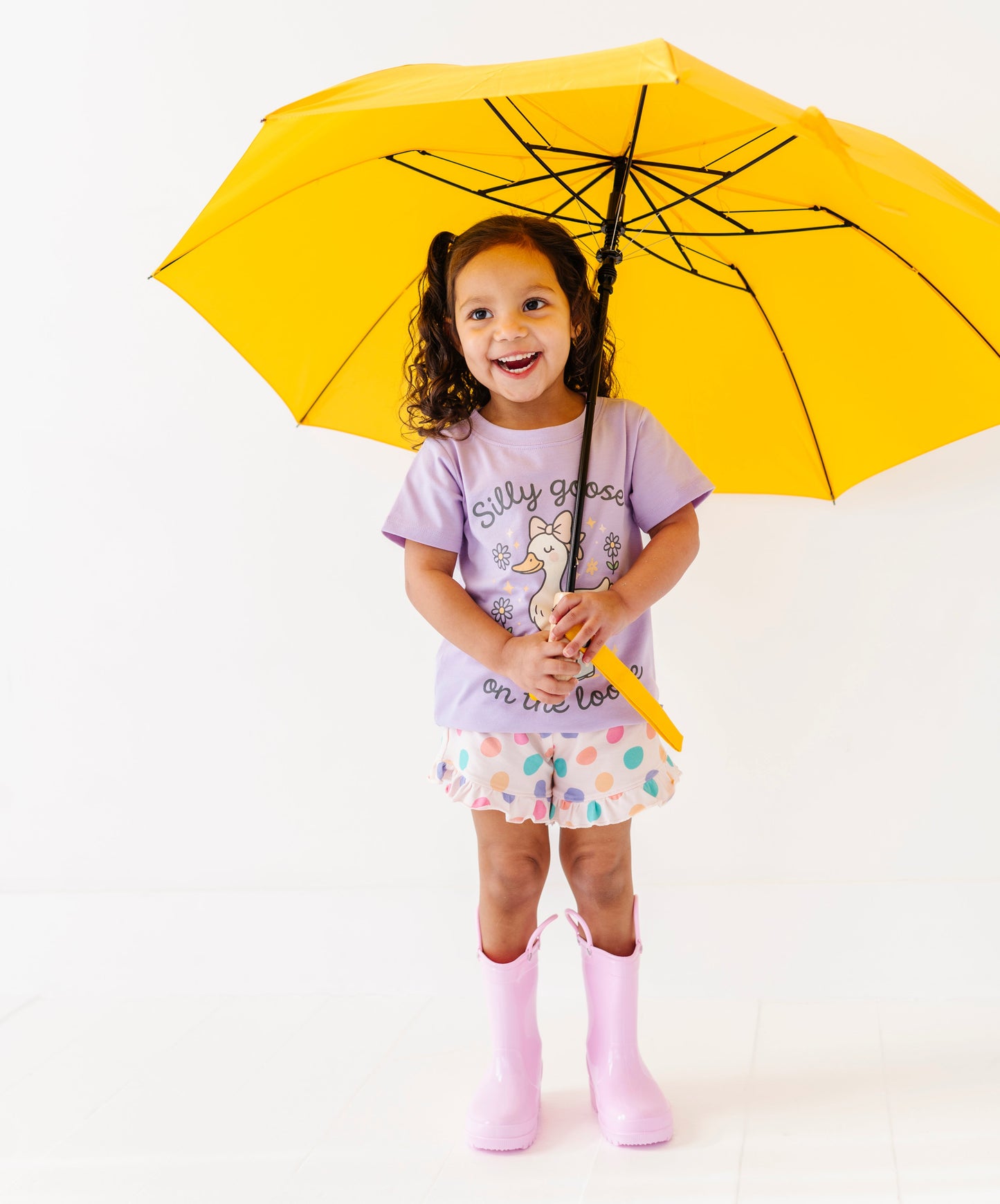 Child holding a yellow umbrella on a white background