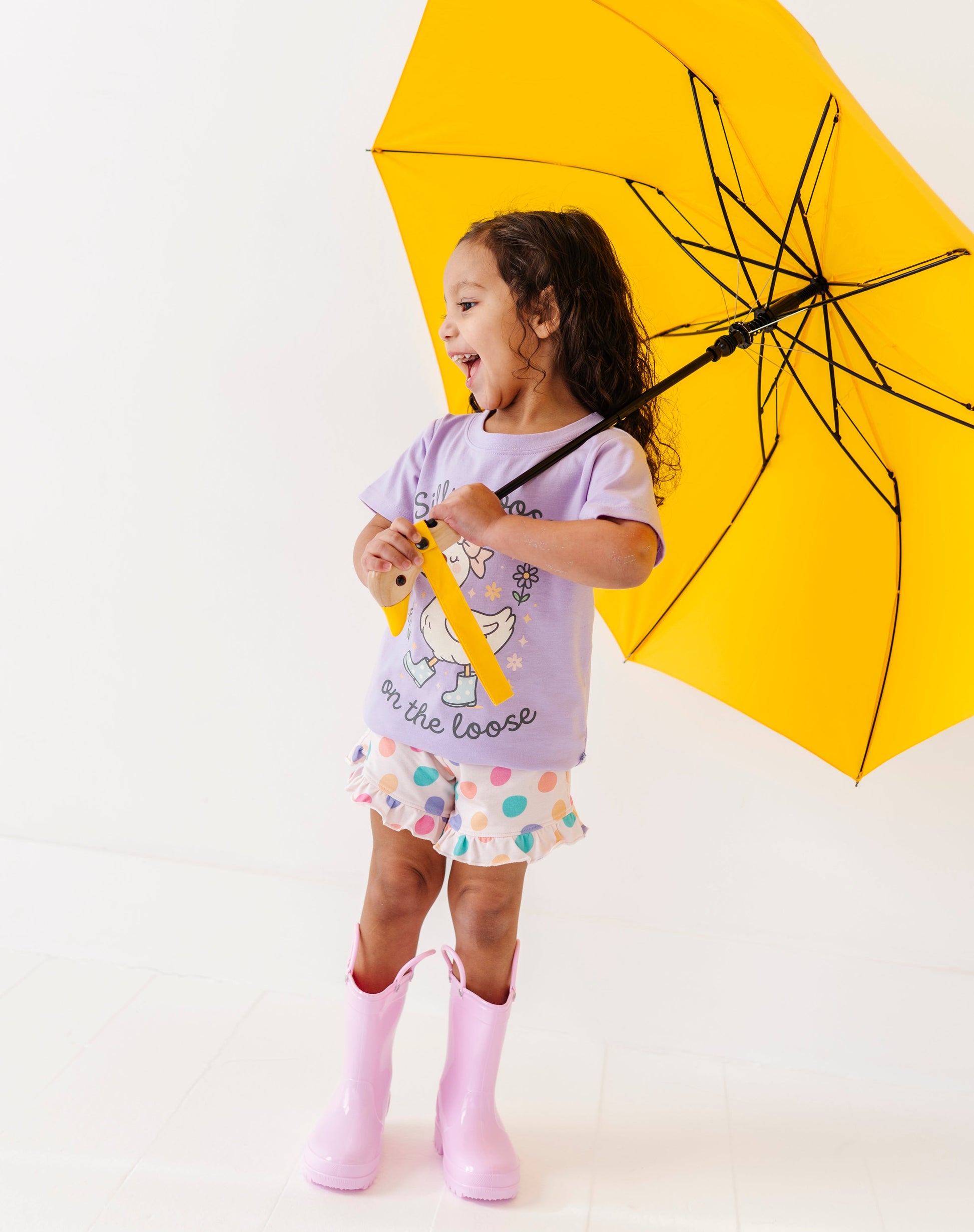 Child holding a yellow umbrella on a white background