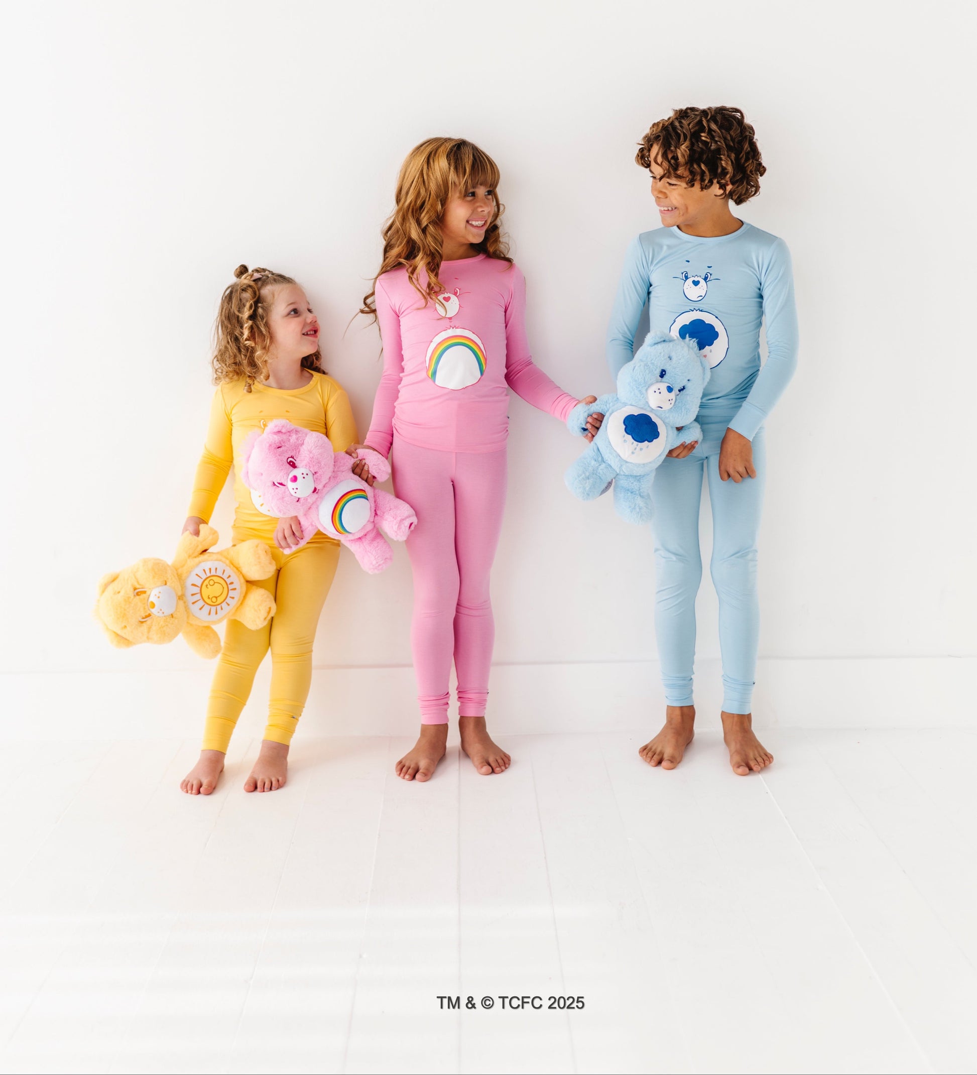 Kids matching Care Bears pajamas featuring Cheer Bear and rainbow design