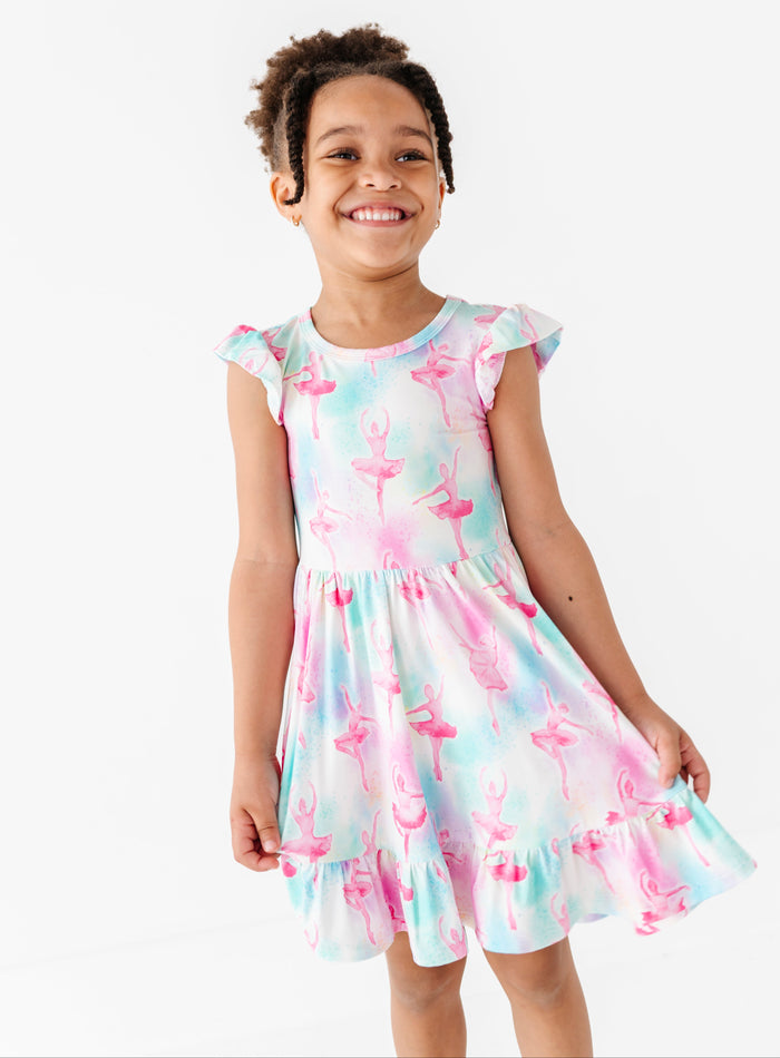Young girl wearing a watercolor ballerina dress on a white background