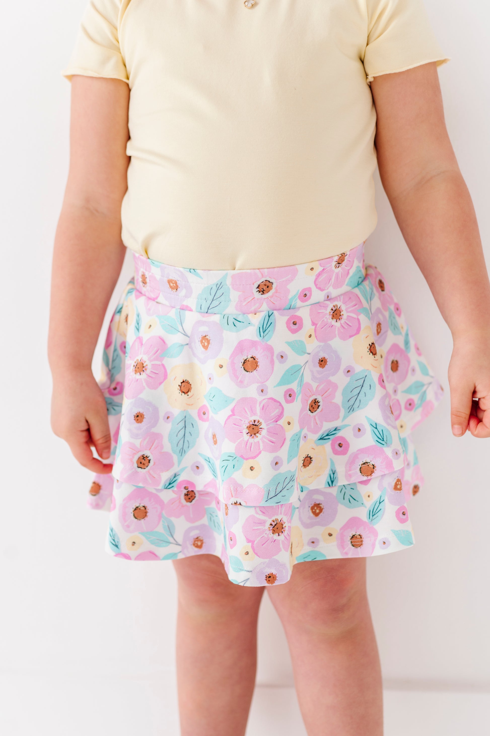 Child wearing a floral bamboo skort with a plain background