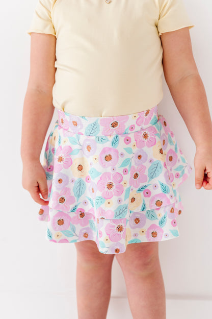 Child wearing a floral bamboo skort with a plain background