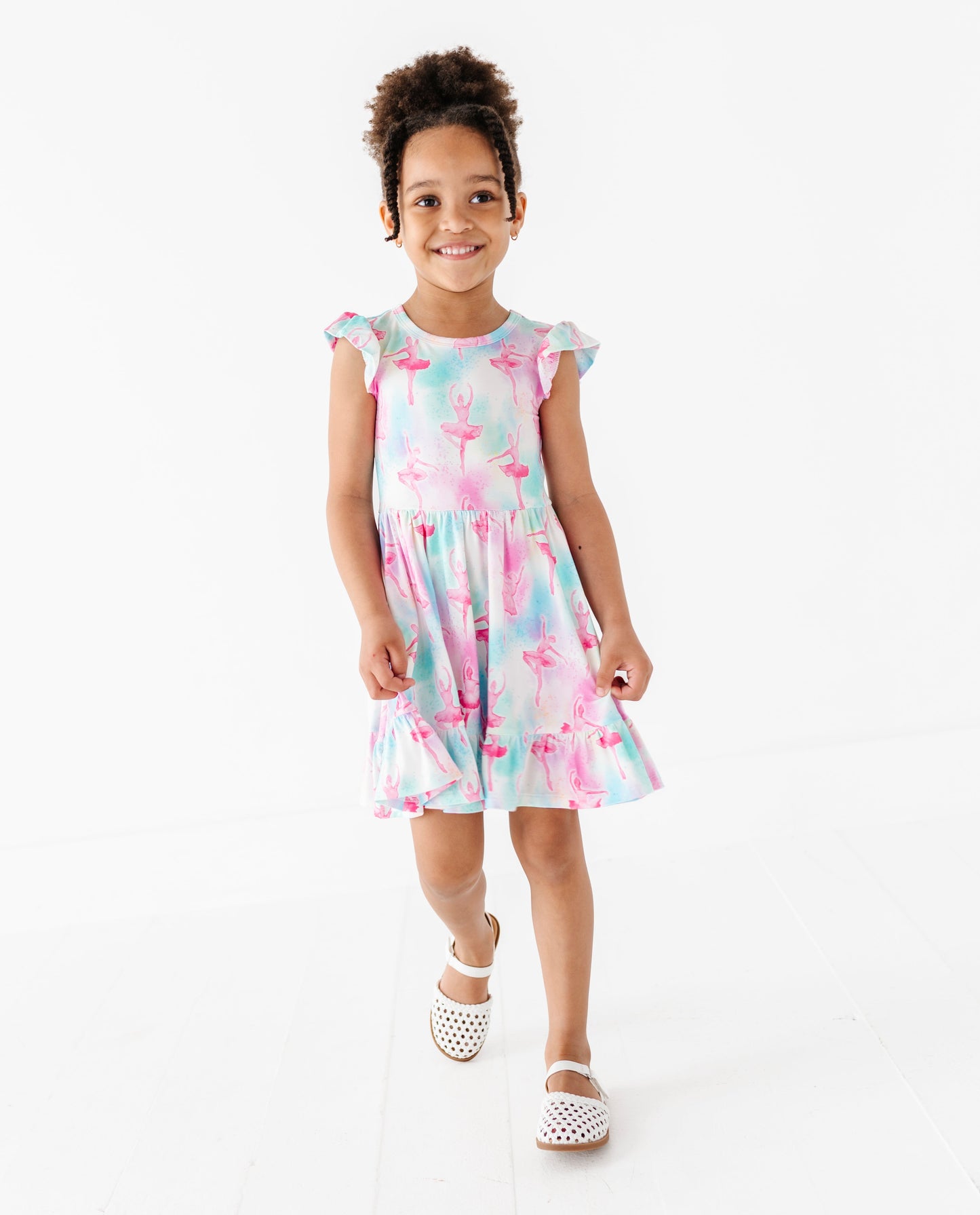Young girl wearing a ballet themed bamboo dress on a white background