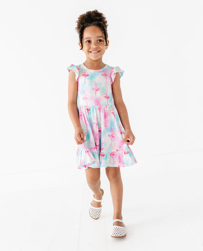 Young girl wearing a ballet themed bamboo dress on a white background