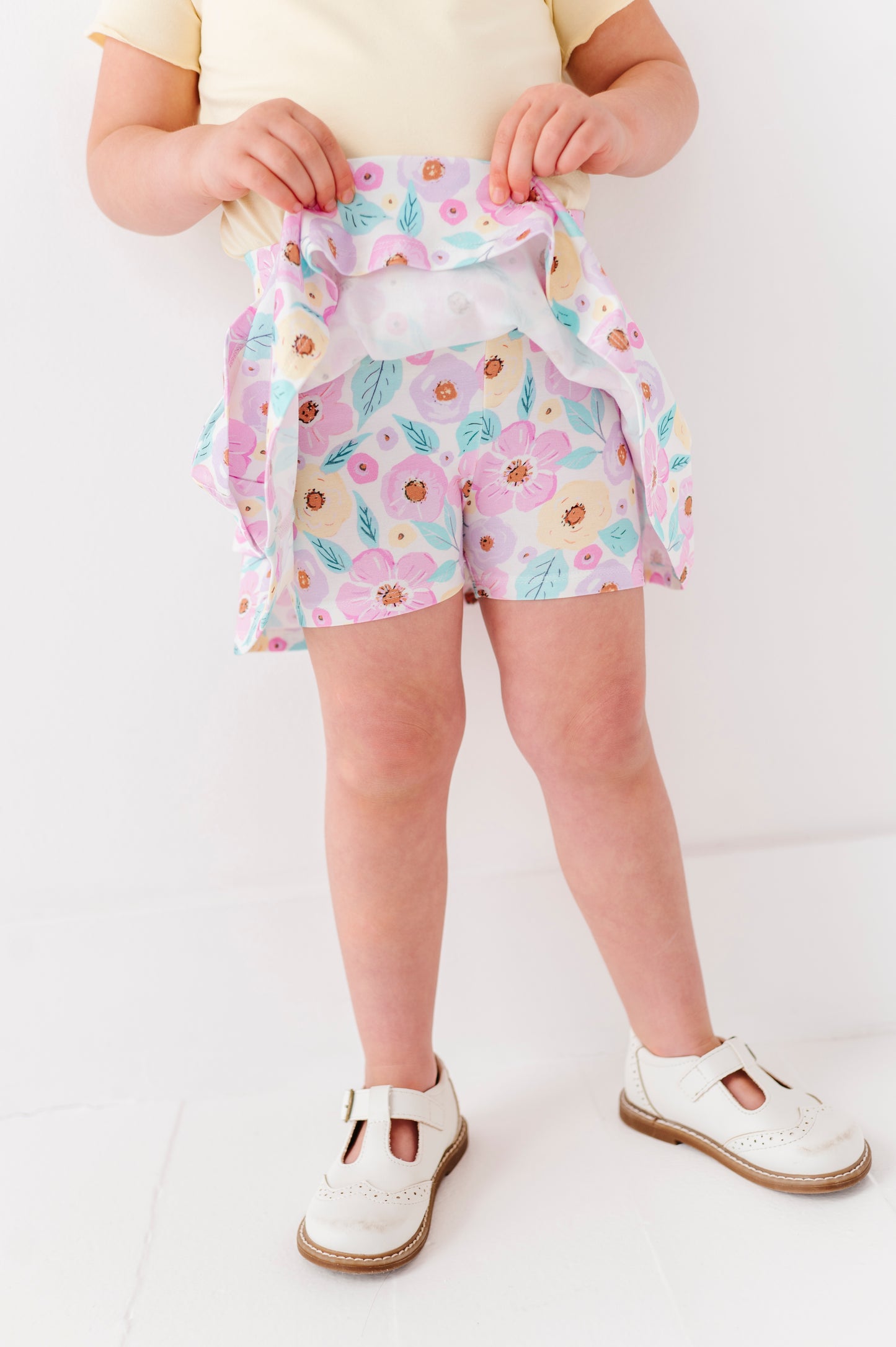Child wearing a floral bamboo skort with a white background