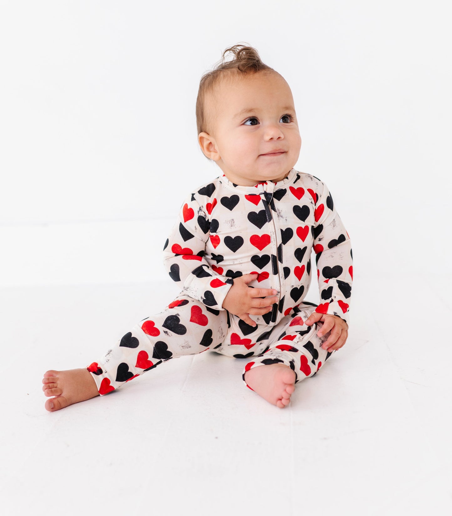 Baby sitting in King of Hearts convertible romper with soft bamboo fabric