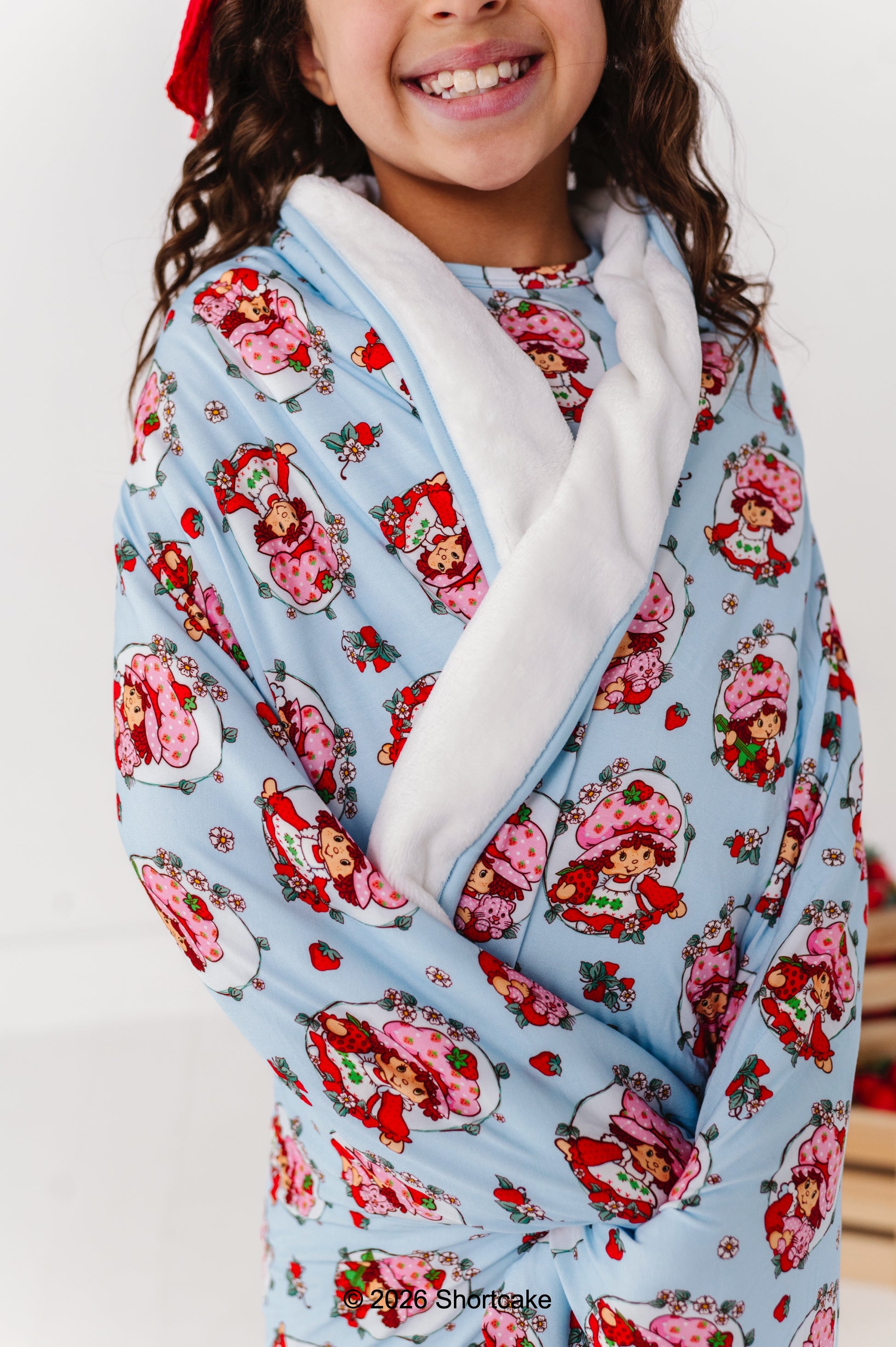 Child wrapped in an officially licensed Strawberry Shortcake™ bamboo blanket 