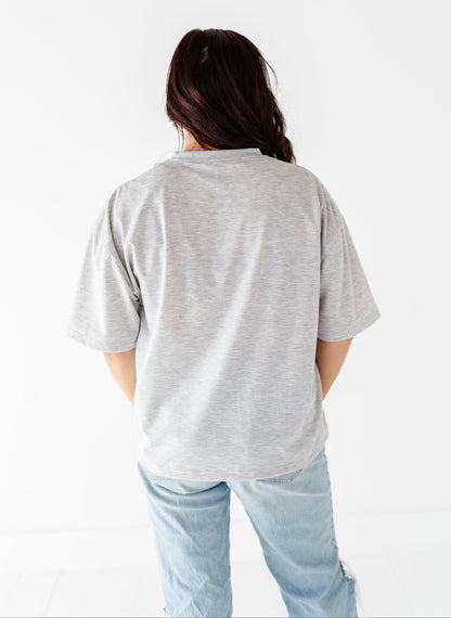 Woman wearing a gray t-shirt and light blue jeans on a white background