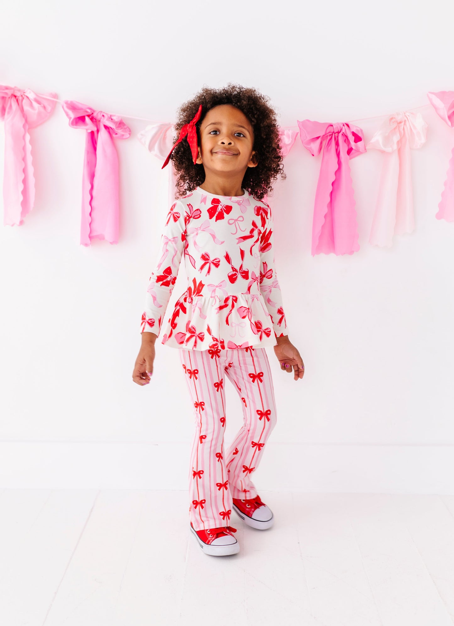 Front view of Blushing Bows long sleeve peplum top for girls