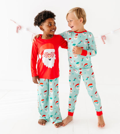 Two children wearing Christmas-themed bamboo pajamas on a white background