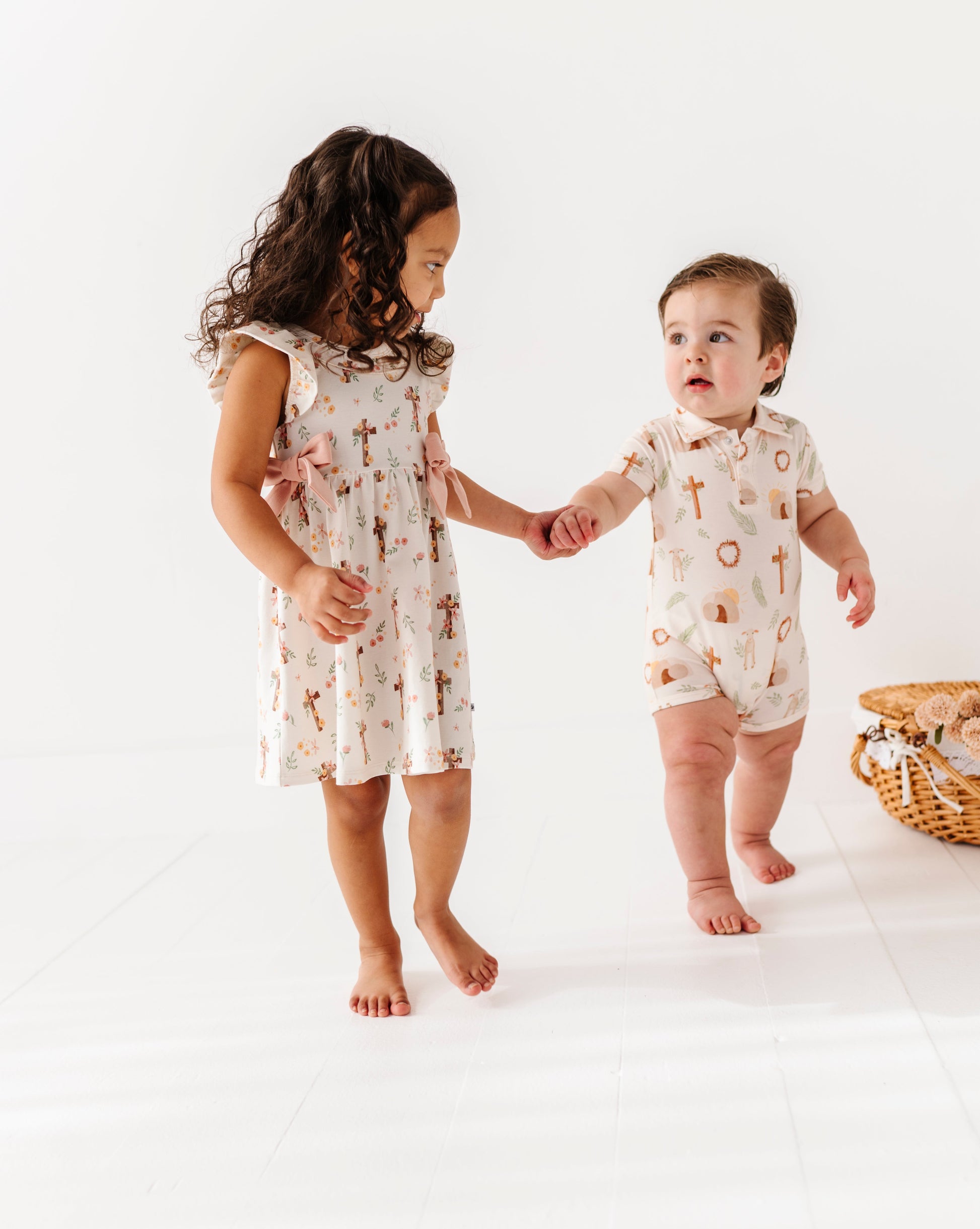Two children in matching Easter outfits standing on a white background