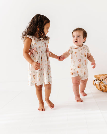Two children in matching Easter outfits standing on a white background