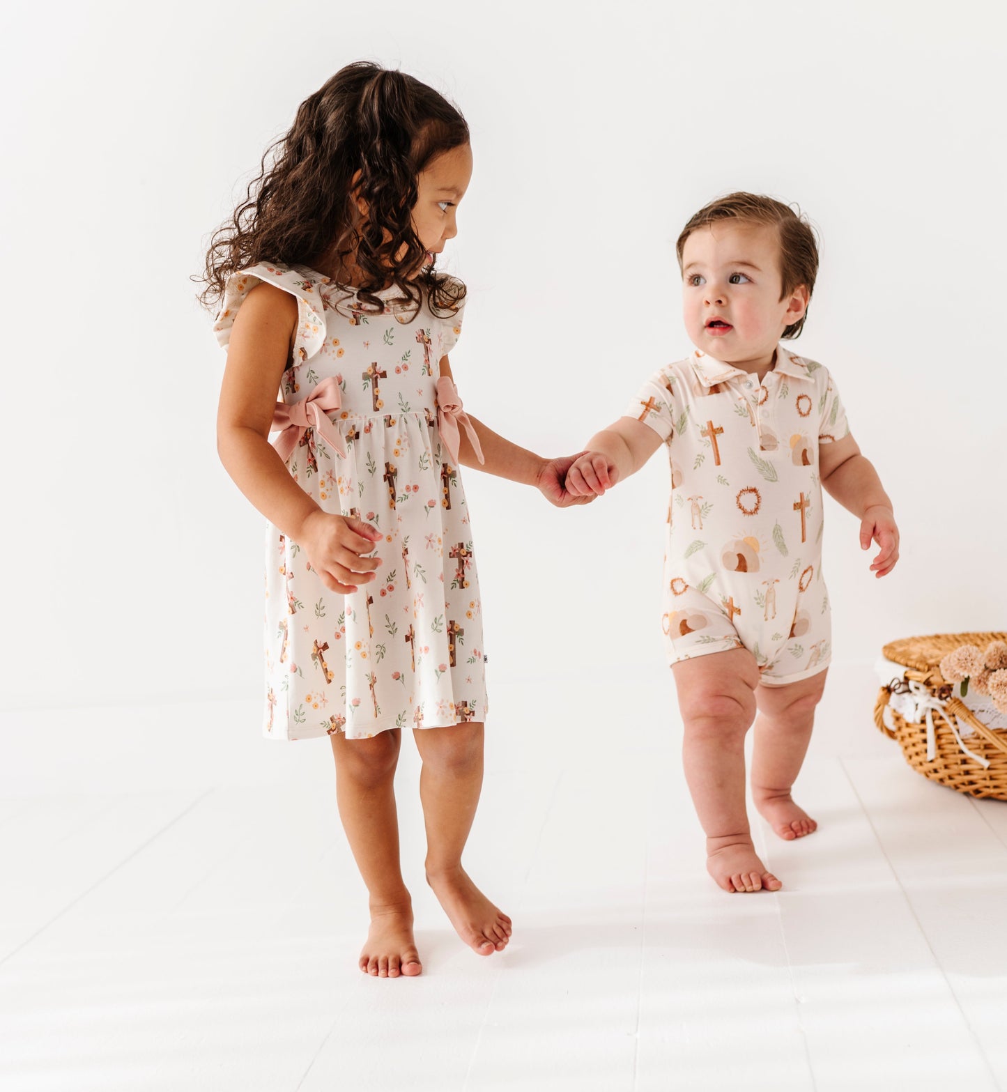 Two children in matching Easter outfits standing on a white background