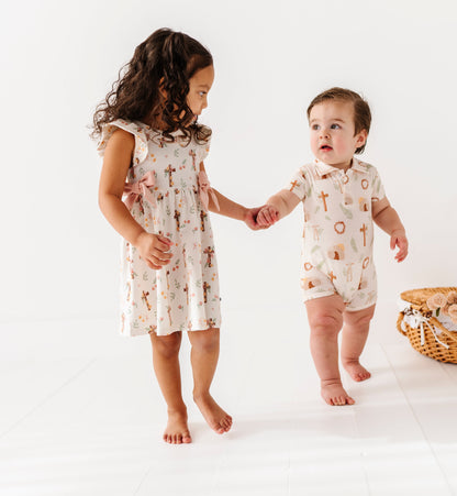 Two children in matching Easter outfits standing on a white background