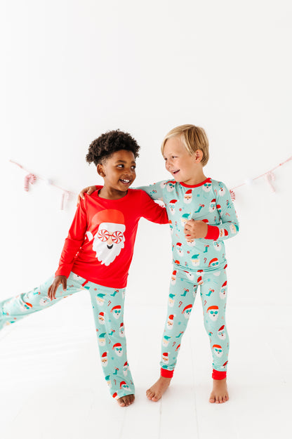 Two children wearing Christmas-themed bamboo pajamas on a white background